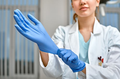 Ärztin trägt medizinische Handschuhe