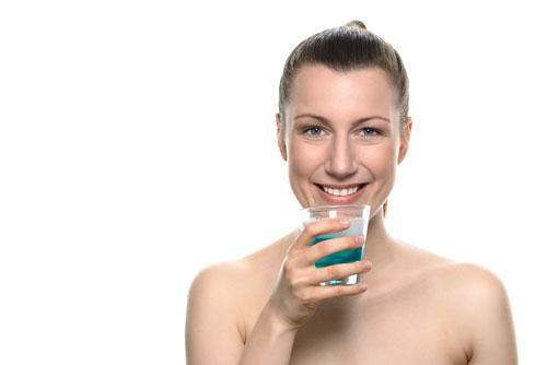 Frau mit einem Glas Mundspülung